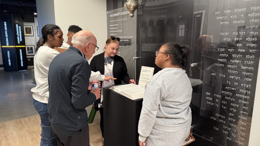 Visitors looking at bok in Alabama Holocaust Education Center