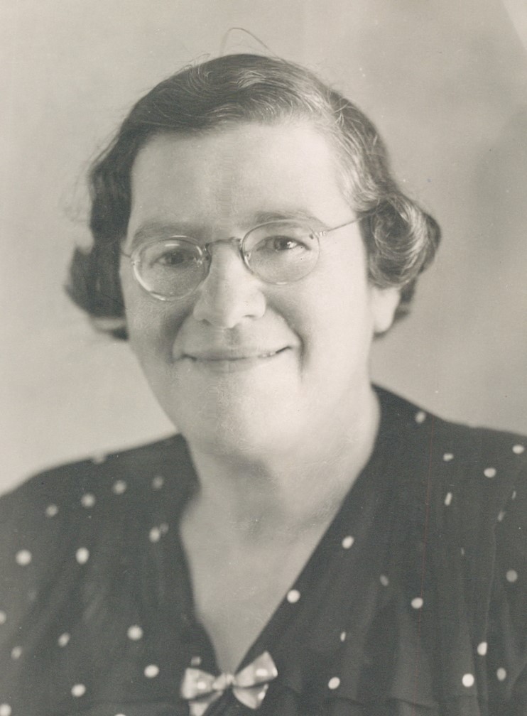 woman smiling wearing glasses and dress