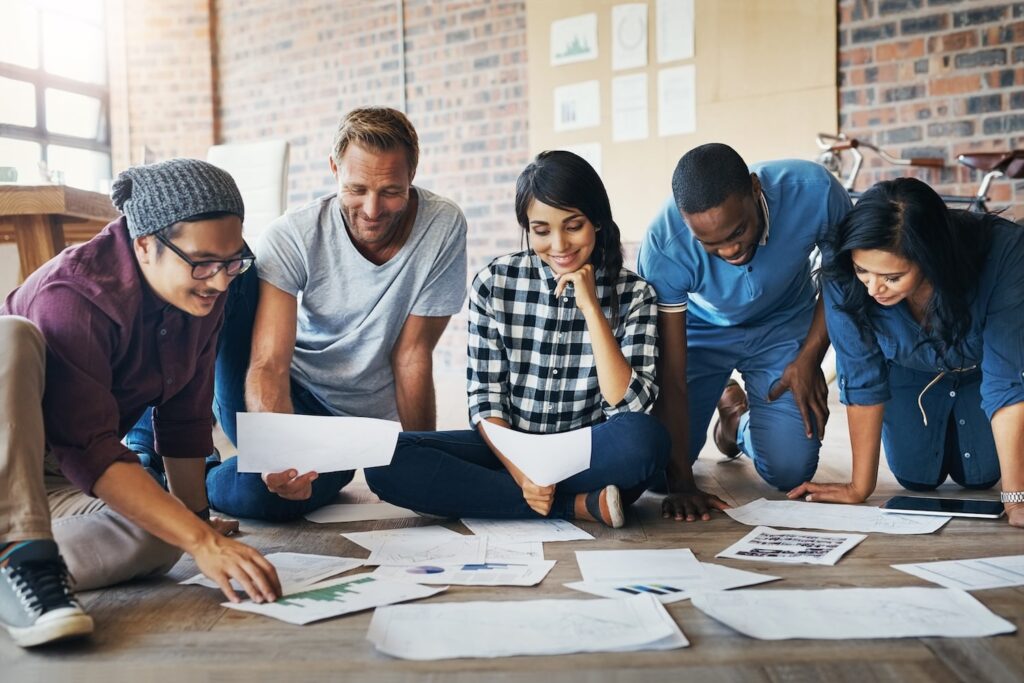Group of people looking at papers on the floor